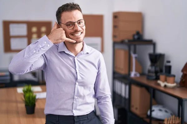 事務所の若いヒスパニック系の男が電話で話すような手や指で携帯電話のジェスチャーをして笑っている コミュニケーションの概念 — ストック写真