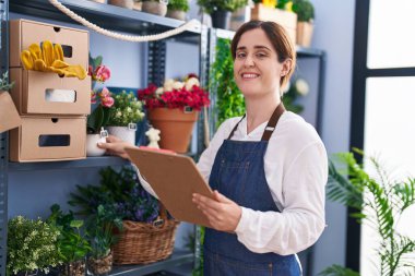 Çiçekçi dükkanında kendine güvenen genç bir çiçekçi.