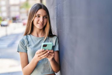 Adorable girl smiling confident using smartphone at street