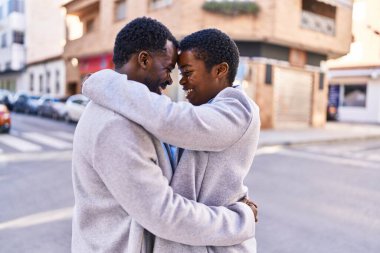 Man and woman couple hugging each other standing at street