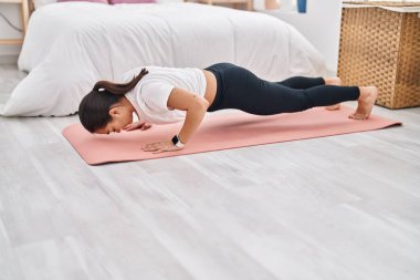 Genç İspanyol kadın antrenmanı. Yatak odasında şınav çek.