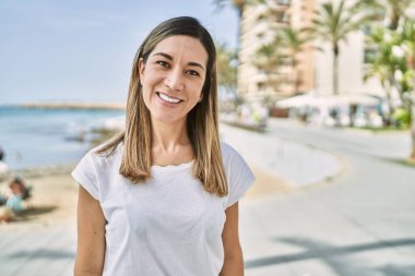 Young hispanic woman smiling confident at seaside