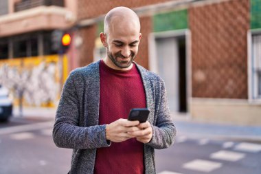 Sokakta akıllı telefon kullanan kendine güvenen genç adam.