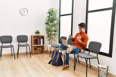 Genç İspanyol adam gülümsüyor. Bekleme odasında kendine güvenen bir video var.