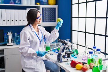 Genç ve güzel İspanyol bilim kadını. Laboratuvarda elma okuma belgesi tutuyor.