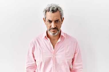 Orta yaşlı İspanyol bir adam soyutlanmış arka planda duruyor şüpheci ve gergin, sorun yüzünden surat asıyor. negatif kişi. 