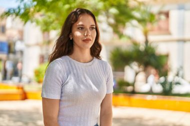 Young woman with relaxed expression standing at park