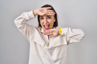 Orta yaşlı İspanyol bir kadın izole edilmiş arka planda durup güler yüzlü bir şekilde yüzünü gösteren bir böceğe bakıyor. Şaşırdım ve çıktım. 