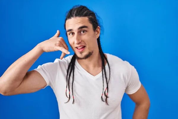 Hispanic Man Long Hair Standing Blue Background Smiling Doing Phone —  Fotos de Stock