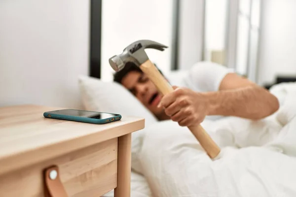 Jovem Hispânico Desligando Despertador Usando Martelo Deitado Cama Quarto — Fotografia de Stock