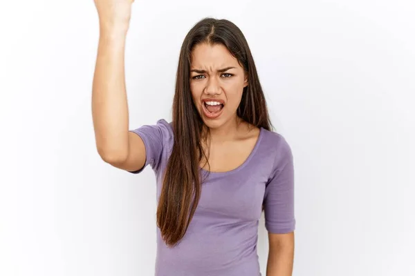 怒りで叫んでいる間に 孤立した背景怒っていると怒っている若いブルネットの女性が拳を上げて激怒しました 怒りと攻撃的な考え方 — ストック写真