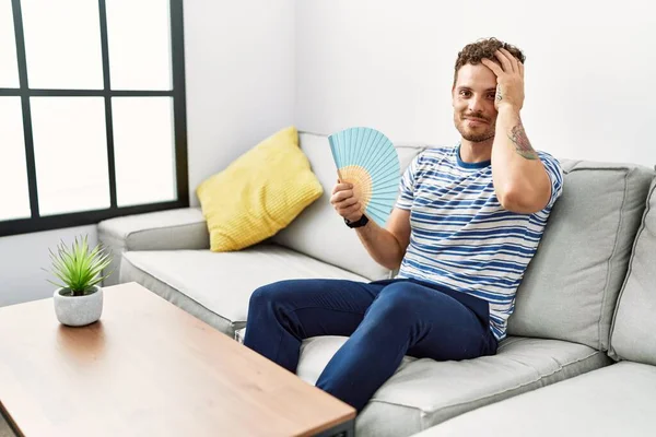 Ung Latinamerikansk Man Ler Säker Med Handfläkt Hemma — Stockfoto