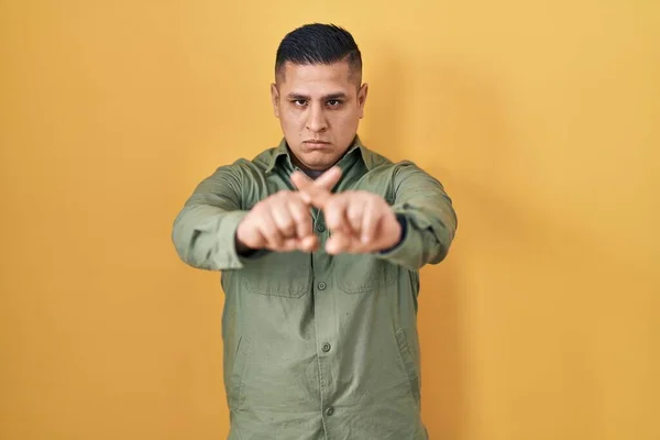 Hiszpan Młody Człowiek Stojący Nad Żółtym Tle Odrzucenie Wyrażenie Skrzyżowanie — Zdjęcie stockowe