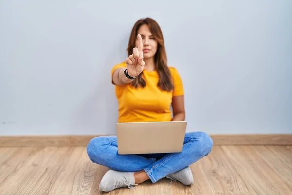 Hispanic Woman Using Laptop Sitting Floor Home Pointing Finger Angry —  Fotos de Stock