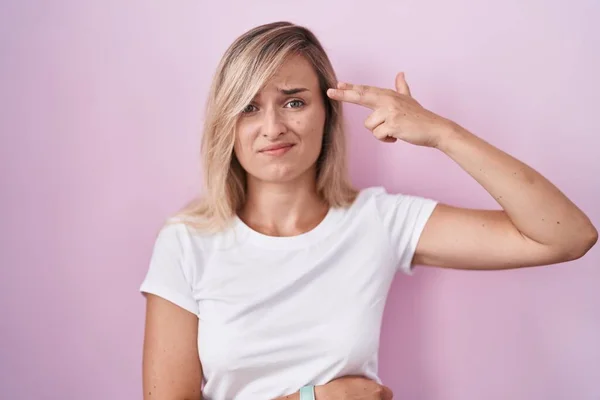 Young Blonde Woman Standing Pink Background Shooting Killing Oneself Pointing — Stockfoto