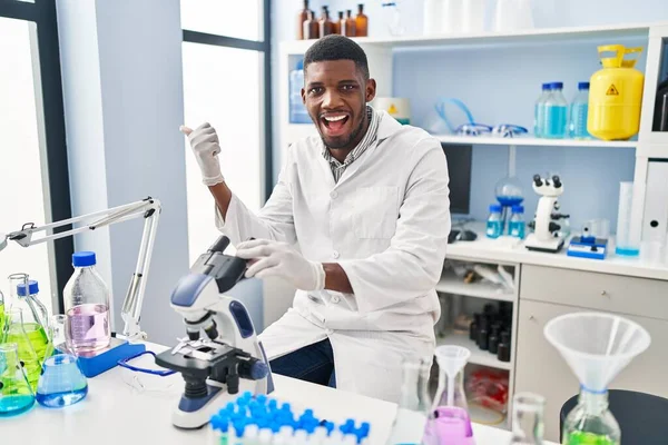 African American Man Working Scientist Laboratory Pointing Thumb Side Smiling — Fotografia de Stock