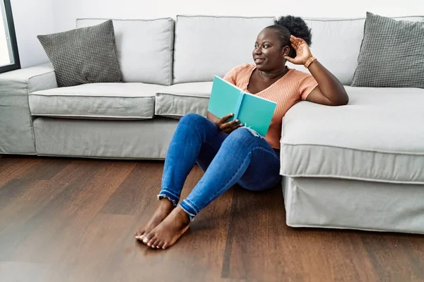 Young African American Woman Reading Book Sitting Floor Home — 图库照片