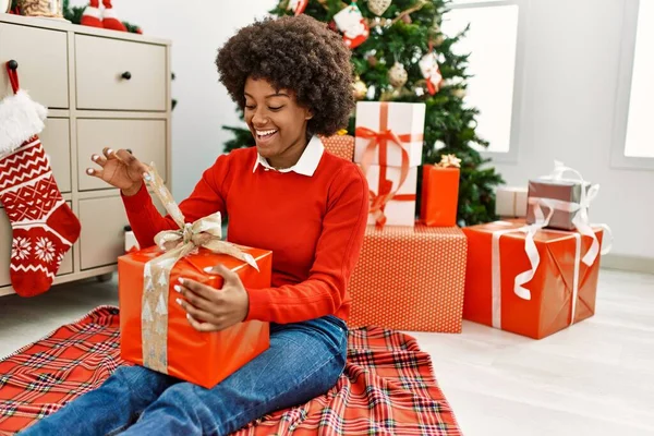 Mladý Africký Americký Žena Odbalení Dárek Sedí Vánočního Stromečku Doma — Stock fotografie
