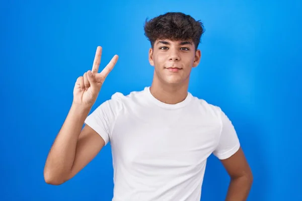 Adolescente Hispana Pie Sobre Fondo Azul Sonriendo Mirando Cámara Mostrando — Foto de Stock