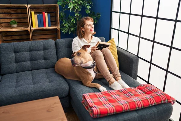 Young Caucasian Woman Looking Photo Sitting Sofa Dog Home — Fotografia de Stock