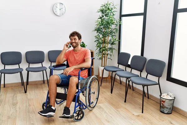 Mladý Hispánec Mluví Smartphonu Sedí Vozíku Čekárně Kliniky — Stock fotografie