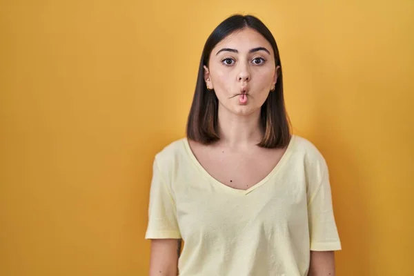 Hispanic Girl Wearing Casual Shirt Yellow Background Making Fish Face — Zdjęcie stockowe