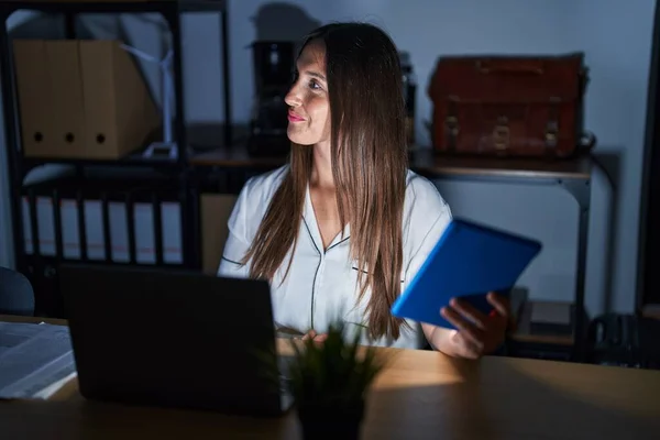 Mulher Morena Jovem Trabalhando Escritório Noite Olhando Para Lado Com — Fotografia de Stock