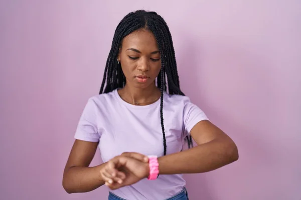 Afroamerikanerin Mit Zöpfen Vor Rosa Hintergrund Die Der Armbanduhr Die — Stockfoto