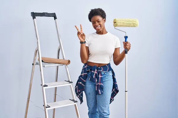 Mulher Afro Americana Segurando Pintor Rolos Sorrindo Com Rosto Feliz — Fotografia de Stock