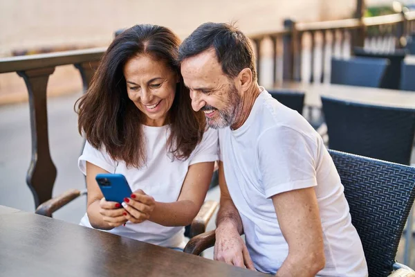 中世の男性と女性のカップルは コーヒーショップテラスでテーブルの上に座ってスマートフォンを使用して — ストック写真