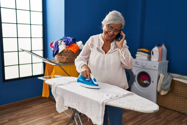 Middle Age Woman Talking Smartphone Ironing Clothes Laundry Room — Stock Photo, Image
