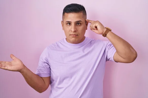 Молодой Латиноамериканец Стоящий Розовом Фоне Смущен Раздражен Открытой Ладонью Показывающей — стоковое фото