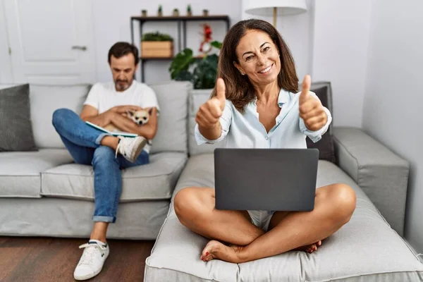 Hispanic Medelålders Par Hemma Kvinna Med Laptop Godkännande Gör Positiv — Stockfoto