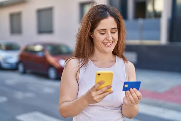ストリートでスマートフォンやクレジットカードを使う若い女性 — ストック写真