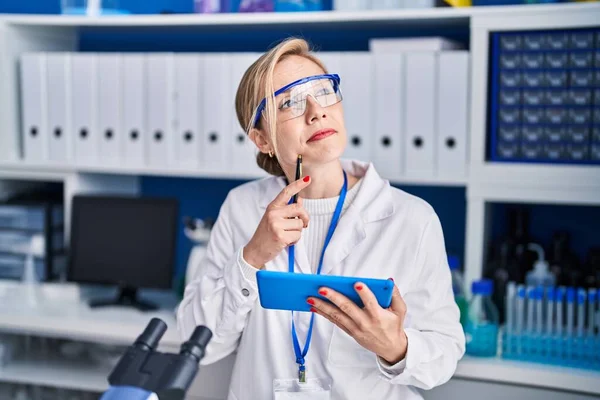 Young Blonde Woman Scientist Using Touchpad Doubt Expression Laboratory — Stock Photo, Image