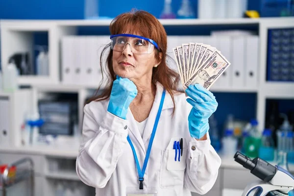 Middle Age Hispanic Woman Working Scientist Laboratory Holding Dollars Serious — ストック写真