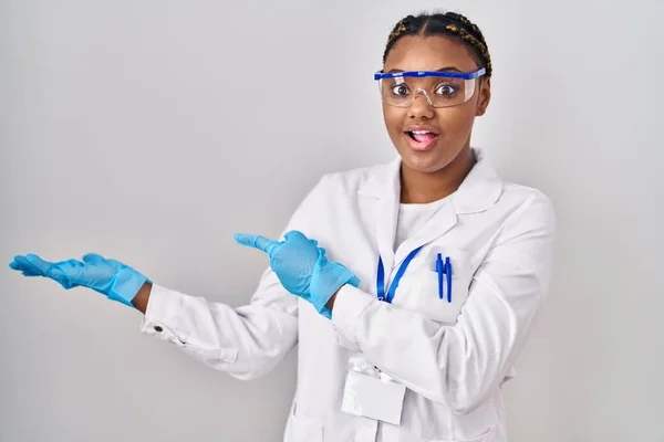 African American Woman Braids Wearing Scientist Robe Amazed Smiling Camera — Stockfoto