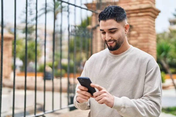 Hombre Árabe Joven Sonriendo Confiado Usando Teléfono Inteligente Calle —  Fotos de Stock