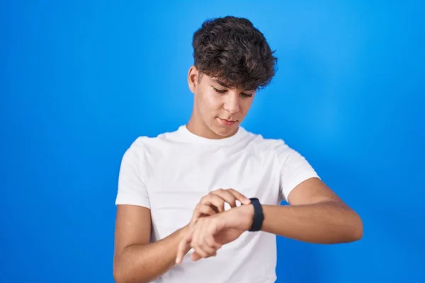 Spaanse Tiener Staan Blauwe Achtergrond Controleren Van Tijd Pols Horloge — Stockfoto