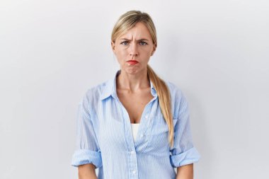 Beyaz arka planda duran güzel sarışın kadın şüpheci ve gergin, sorun yüzünden surat asıyor. negatif kişi. 