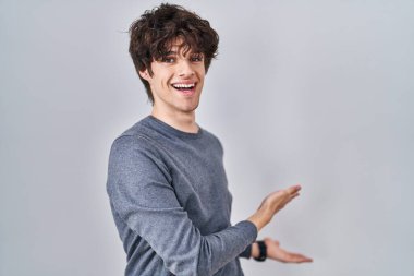 İzole edilmiş arka planda duran genç adam gülümseyerek içeri girmeye davet ediyor. 