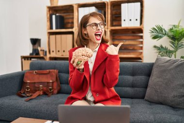 Muayenehanedeki genç esmer kadın beyni elinde tutarak baş parmağını yukarı kaldırıyor ve ağzı açık gülümsüyor. 