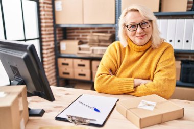 Middle age blonde woman ecommerce business worker working at office