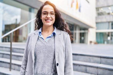 Sokakta kendine gülen genç İspanyol kadın yönetici.