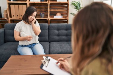 Down sendromlu İspanyol kız terapi yapıyor. Stresli ve gergin görünüyor. Ağzı tırnak yiyen ellerle. anksiyete. 