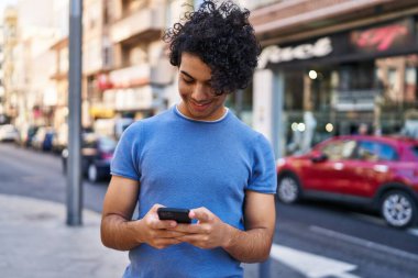 Sokakta akıllı telefon kullanan, kendine güvenen genç bir İspanyol.