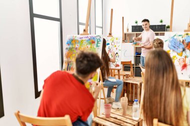 Group of people smiling happy having paint class at art studio.