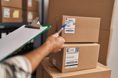 Genç İspanyol iş adamı ofiste etiket paketine işaret ediyor.