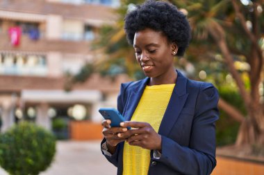 Young african american woman business executive using smartphone at park