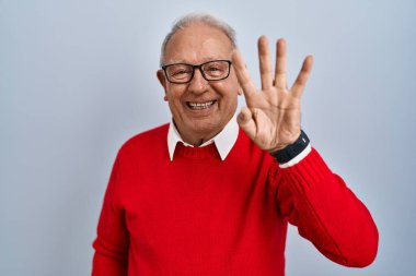 İzole edilmiş arka planda gri saçlı yaşlı adam dört numaralı parmaklarıyla gülümseyerek kendinden emin ve mutlu olduğunu gösteriyor.. 